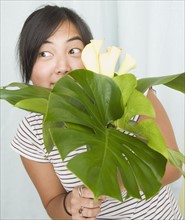 Woman peeking over leaves and flowers. Date : 2007