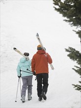 Couple walking with skis over shoulders. Date : 2007