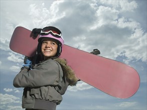 Snowboarder holding board on shoulder. Date : 2007