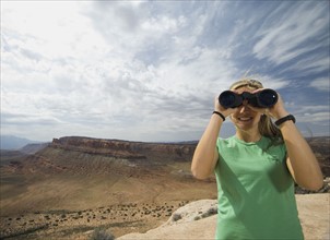Woman looking through binoculars. Date : 2007