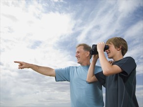 Father and son using binoculars. Date : 2007