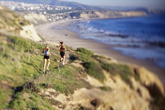 Women jogging on cliff along water. Date : 2007