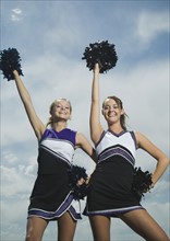Two cheerleaders holding pom poms. Date : 2007