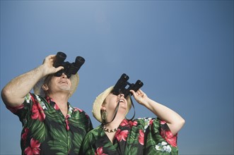 Senior couple looking through binoculars. Date : 2007