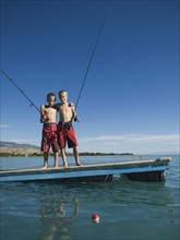 Brothers fishing off dock in lake, Utah, United States. Date : 2007