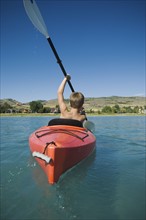 Boy paddling in canoe on lake, Utah, United States. Date : 2007