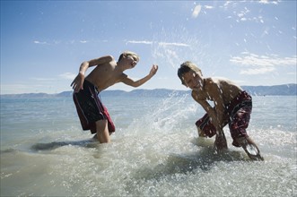 Brothers splashing in lake, Utah, United States. Date : 2007