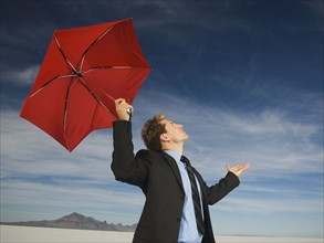 Businessman holding umbrella, Salt Flats, Utah, United States. Date : 2007