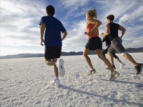 Group of people running on salt flats, Utah, United States. Date : 2007