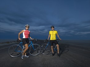 Couple with bicycles on road, Utah, United States. Date : 2007