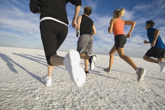 Group of people running on salt flats, Utah, United States. Date : 2007
