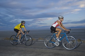 Couple cycling on road, Utah, United States. Date : 2007