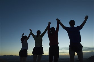 Silhouette of people with arms raised, Salt Flats, Utah, United States. Date : 2007