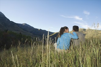 Couple sitting on hillside, Utah, United States. Date : 2007