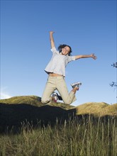Woman jumping in field, Utah, United States. Date : 2007