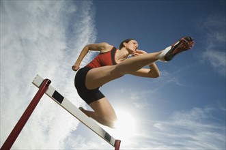 Female athlete jumping hurdle, Utah, United States. Date : 2007