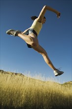 Low angle view of woman jumping, Salt Flats, Utah, United States. Date : 2007