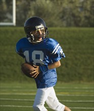 Young football player running with ball. Date : 2007