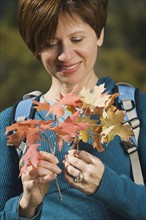 Woman holding autumn leaves, Utah, United States. Date : 2007