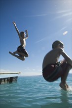 Brothers jumping off dock into lake, Utah, United States. Date : 2007