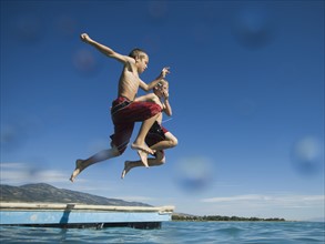 Brothers jumping off dock into lake, Utah, United States. Date : 2007