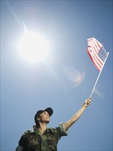 Female army soldier holding American flag. Date : 2007
