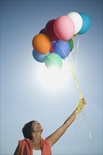 Woman holding bunch of balloons. Date : 2007