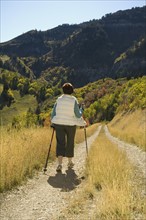 Senior woman walking with hiking poles, Utah, United States. Date : 2007