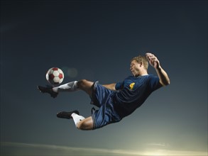 Man kicking soccer ball in air. Date : 2007