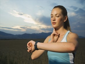 Woman in athletic gear checking pulse. Date : 2007