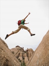 Woman jumping over rock formation. Date : 2007