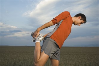 Man in athletic gear stretching. Date : 2007
