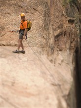 Man in rappelling gear at top of cliff. Date : 2007