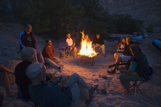 People relaxing around camp fire. Date : 2007