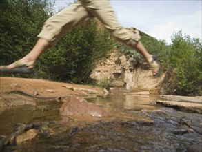 Woman jumping over stream. Date : 2007