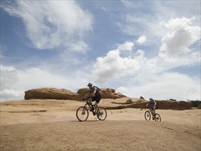 Couple riding mountain bikes in desert. Date : 2007