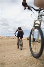 Low angle view of couple riding mountain bikes. Date : 2007