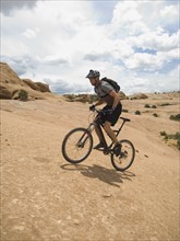 Man riding mountain bike on rock formation. Date : 2007