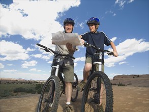 Father and son on mountain bikes with map. Date : 2007
