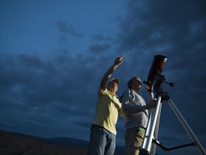 Couple using telescope on tripod. Date : 2007