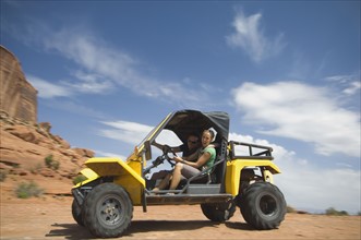 Woman driving off-road vehicle in desert. Date : 2007