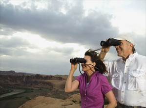 Couple looking through binoculars. Date : 2007