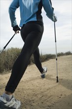 Hispanic woman pole walking along coast in California, United States. Date : 2007
