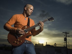 Man playing guitar at dusk. Date : 2007
