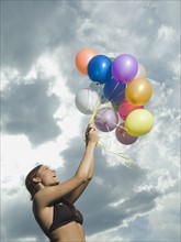 Woman holding bunch of balloons. Date : 2007