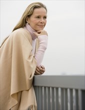 Woman leaning on railing.