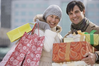 Couple carrying shopping bags and gifts.