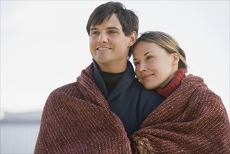 Couple wrapped in blanket.