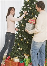 Couple decorating Christmas tree.