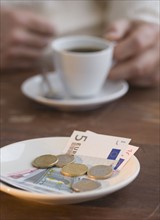 Euros on plate at cafe.